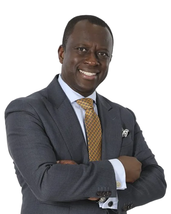 Professional Black man wearing a gray suit, white shirt, and yellow patterned tie, smiling with arms crossed.
